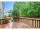 Red-toned wood deck and railing with lush greenery and shade trees surround the property at 732 Sweet Gum Way, Canton, GA 30115