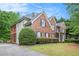 A lush green lawn surrounds this two-story brick home with a screened porch and private driveway at 732 Sweet Gum Way, Canton, GA 30115