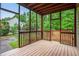 Open air screened-in porch with wooden deck floor, surrounded by lush green trees at 732 Sweet Gum Way, Canton, GA 30115