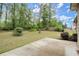 Lush backyard with a concrete patio surrounded by mature trees and greenery at 74 Stonegate Ct, Dallas, GA 30157