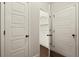 Hallway with white doors, one leading to closet with a wire shelf at 74 Stonegate Ct, Dallas, GA 30157