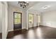 Elegant dining area with dark hardwood floors, chandelier, and natural light from the large windows at 74 Stonegate Ct, Dallas, GA 30157