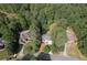 A beautiful home nestled among mature trees, complete with a driveway, backyard, and surrounding green spaces at 1725 Redbud Way, Cumming, GA 30041