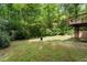 Spacious backyard featuring a lush lawn, mature trees, and a wooden deck, perfect for relaxation and recreation at 1725 Redbud Way, Cumming, GA 30041