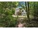 Secluded backyard with mature trees, a wooden deck, and serene natural surroundings at 1725 Redbud Way, Cumming, GA 30041