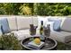 Up close view of a relaxing deck featuring a sofa with throw pillows, wine, and a glass coffee table at 1725 Redbud Way, Cumming, GA 30041