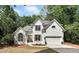 Beautifully landscaped two-story home with a well-maintained front yard and attached garage in a wooded setting at 1725 Redbud Way, Cumming, GA 30041