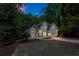 Charming two-story home with landscaped yard and attached garage in a wooded setting at dusk at 1725 Redbud Way, Cumming, GA 30041