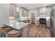 Bright kitchen features stainless steel appliances, white cabinets, quartz countertops, and wood floors at 1725 Redbud Way, Cumming, GA 30041
