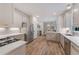 Open kitchen featuring stainless steel appliances, white cabinets, quartz countertops and wood floors at 1725 Redbud Way, Cumming, GA 30041