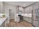 Charming kitchen featuring stainless steel appliances, white cabinets, and stylish wood flooring at 1725 Redbud Way, Cumming, GA 30041