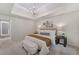 This main bedroom features a tray ceiling, a decorative light fixture, a bench and neutral decor at 1725 Redbud Way, Cumming, GA 30041