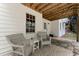 Charming covered patio with stone flooring, comfortable seating, and a view of the landscaped yard at 1725 Redbud Way, Cumming, GA 30041