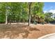 Community playground features swing set and slides with a bordering tennis court, and lush trees nearby at 1725 Redbud Way, Cumming, GA 30041