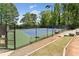 Community tennis court surrounded by black fence, featuring green and blue playing surface at 1725 Redbud Way, Cumming, GA 30041