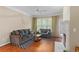 Sunlit living room with hardwood floors, comfortable seating, and a charming fireplace at 221 Ashford Cir, Atlanta, GA 30338