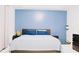 Modern bedroom with blue wall, stylish dark wood furniture, and a comfortable bed with blue bedding at 2568 Morning Glory Pl, Lawrenceville, GA 30044