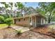 Brick home with a patio area surrounded by lush greenery and a chainlink fence at 2729 Lanier Dr, Snellville, GA 30078