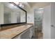 Bathroom featuring granite counters, a large mirror, and a sink with storage beneath, plus access to a shower at 2729 Lanier Dr, Snellville, GA 30078