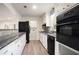 Kitchen featuring modern appliances, granite countertops, white cabinets, and hardwood flooring at 2729 Lanier Dr, Snellville, GA 30078