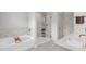 Bright bathroom featuring a separate tub and shower with marble style tile at 3493 Monarch Ave, Duluth, GA 30096