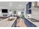 Open concept kitchen features marble countertops, custom blue cabinets, island with seating and a view to the living room at 3493 Monarch Ave, Duluth, GA 30096