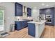 Modern kitchen features blue cabinets, stainless appliances, marble counters and backsplash, and a large island at 3493 Monarch Ave, Duluth, GA 30096