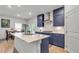 Bright kitchen boasts custom blue cabinets, marble counters, stainless hood, an island, and an eat-in kitchen table at 3493 Monarch Ave, Duluth, GA 30096