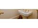 Small bathroom with a white pedestal sink and gold fixtures, creating an elegant and functional space at 3672 Haddon Hall Rd, Atlanta, GA 30327