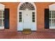 Close-up of arched front door with sidelights, flanked by black shutters and brick facade at 3672 Haddon Hall Rd, Atlanta, GA 30327