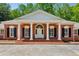 Close up of brick home's entry featuring white columns, black shutters and a beautiful arched door at 3672 Haddon Hall Rd, Atlanta, GA 30327
