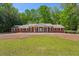 Charming, one-story brick home with mature trees, a spacious lawn, and a welcoming front entrance with white columns at 3672 Haddon Hall Rd, Atlanta, GA 30327