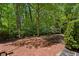 Enjoy the outdoors on this brick patio surrounded by lush greenery and mature trees for optimal privacy at 3672 Haddon Hall Rd, Atlanta, GA 30327