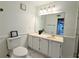 Bathroom vanity with neutral countertops, white cabinetry, and large framed mirror at 1409 Oakridge Cir, Decatur, GA 30033
