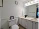 Well-lit bathroom with dual sinks, white cabinets, and a large mirror at 1409 Oakridge Cir, Decatur, GA 30033