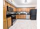 Kitchen featuring stainless appliances, wooden cabinets, granite countertops, and marble floors at 1409 Oakridge Cir, Decatur, GA 30033