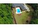 Aerial view of a red brick house with a swimming pool and a large, meticulously maintained yard surrounded by trees at 850 Cog Hl, Mcdonough, GA 30253