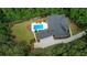 View of the brick home surrounded by tall green trees; the yard features a pool and manicured landscaping at 850 Cog Hl, Mcdonough, GA 30253