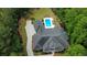 An aerial view of the large brick house with a dark gray roof surrounded by a lush green forest and large driveway at 850 Cog Hl, Mcdonough, GA 30253