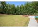 Large backyard with mature trees and professional landscaping, leading to the pool area at 850 Cog Hl, Mcdonough, GA 30253