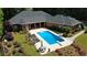 Backyard pool area with lounge chairs, table seating, manicured landscaping, and a red brick home at 850 Cog Hl, Mcdonough, GA 30253