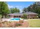 Manicured backyard featuring a swimming pool, lounge area, mature trees, and meticulous landscaping at 850 Cog Hl, Mcdonough, GA 30253