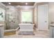 Bright bathroom featuring a walk-in shower, soaking tub, neutral walls, and tile flooring at 850 Cog Hl, Mcdonough, GA 30253