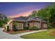 Beautiful exterior view of the house highlighting the architectural details and lush landscaping at sunset at 850 Cog Hl, Mcdonough, GA 30253