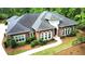 Aerial view of a red brick home with a well-manicured lawn, lush landscaping, and mature trees at 850 Cog Hl, Mcdonough, GA 30253