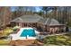 A backyard swimming pool is featured with umbrellas, a diving board and an expansive seating area at 850 Cog Hl, Mcdonough, GA 30253