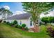 Beautifully landscaped backyard featuring mature trees, manicured lawn, and a charming white home exterior at 2752 Nautical Way, Villa Rica, GA 30180