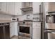 Modern kitchen featuring stainless steel appliances, white cabinets, and stylish backsplash at 2752 Nautical Way, Villa Rica, GA 30180