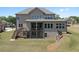 Back exterior featuring a large yard, deck, patio, and retaining wall with a landscaped area at 4800 Gablestone Xing, Hoschton, GA 30548