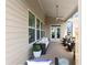 This covered deck features comfortable seating, a ceiling fan, and a door to the outside at 4800 Gablestone Xing, Hoschton, GA 30548